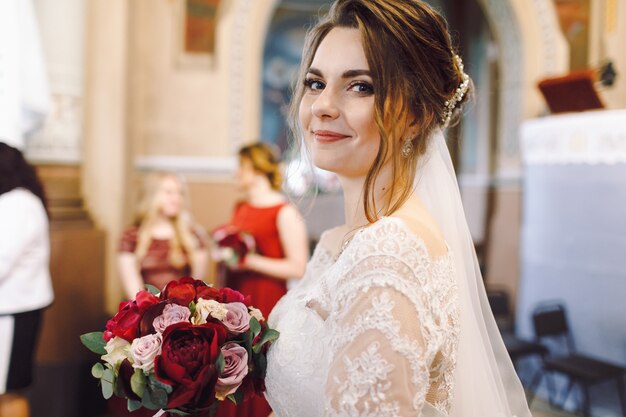 De bruid kijkt aanbiddelijk tijdens de ceremonie in kerk