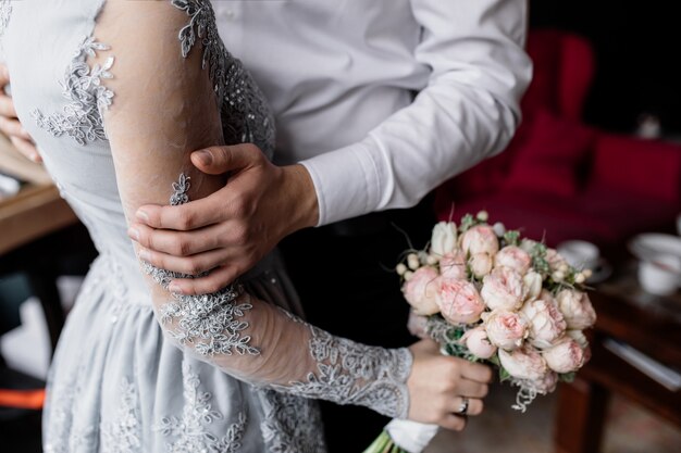 De bruidegom houdt zijn geliefde hand vast