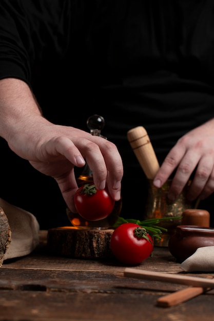 De chef bereidt tomaat op bureau voor