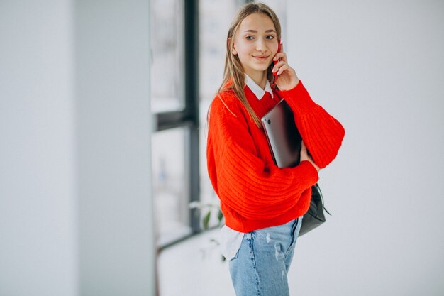 De computer van de studenteholding en het spreken op de telefoon door het venster