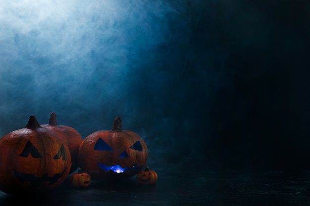 Gratis foto de decoratieve pompoenen van halloween met binnen verlichting en rook