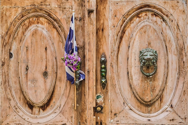 De deur van een oud huis versierd met de vlag van Griekenland en een krans van Protomaya de stad Rhodos een reis naar de populaire plaatsen van de Dodekanesos-archipel Griekenland