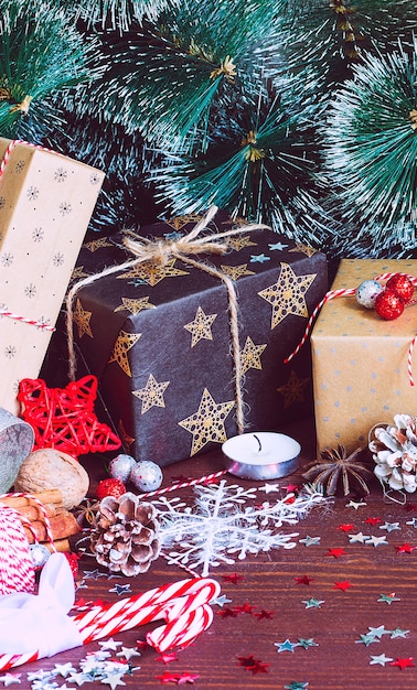 De doos van de de vakantiegift van Kerstmis op verfraaide feestelijke lijst met van het de takkensnee van pijnboomkegels de rietnoten