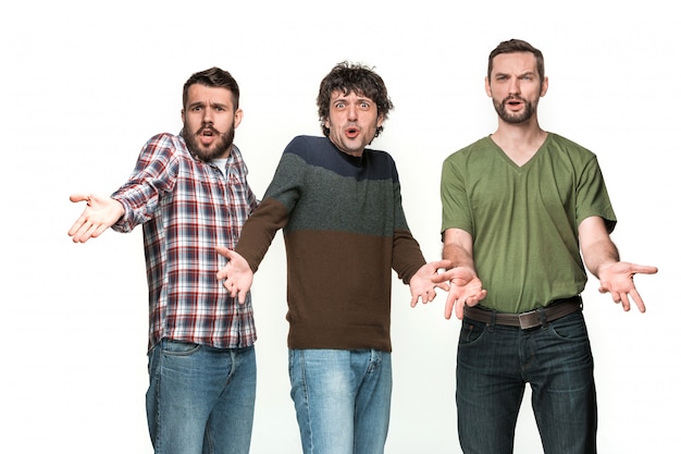 De drie mannen glimlachen en kijken naar de camera