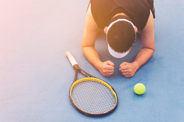 De droevige tennisspeler die in het hof zit na verliest een gelijke