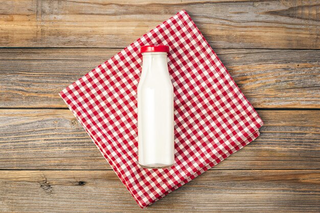 De fles melk op een houten witte vlakke ondergrond lag