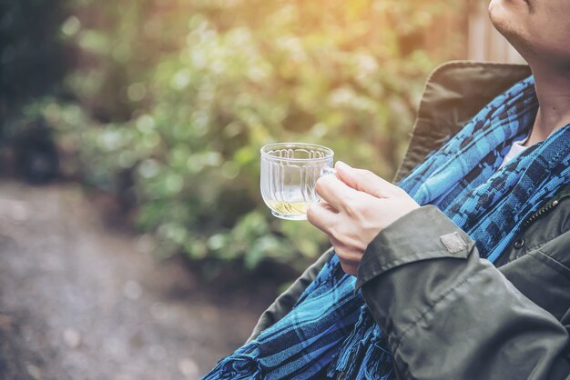 De gelukkige mens drinkt hete theekop - de Aziatische mensen met hete theedrank ontspant concept