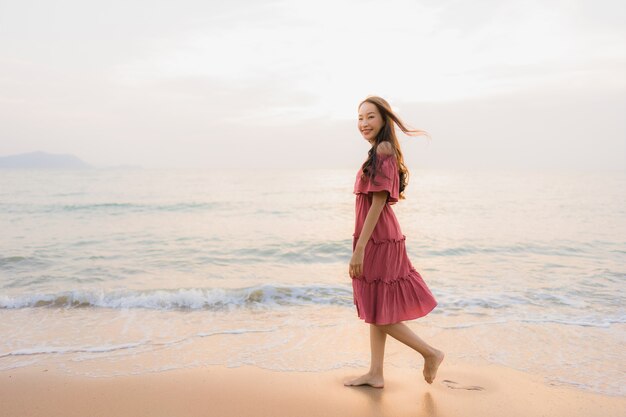 De gelukkige vrije tijd van de portret mooie jonge Aziatische vrouw gelukkige op het strandoverzees en de oceaan