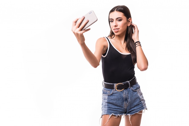 De glimlachende dame maakt in het kort selfie op haar geïsoleerde telefoon