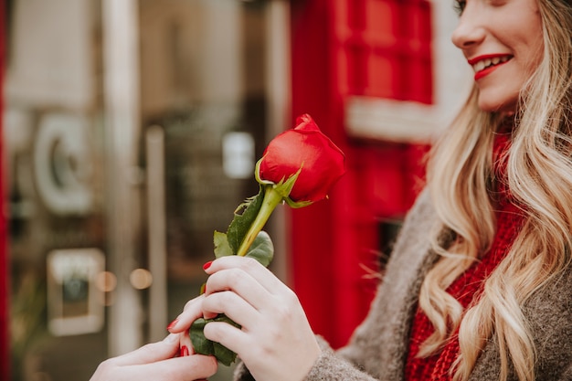 De glimlachende vrouw die rood nam nam van de mens toe