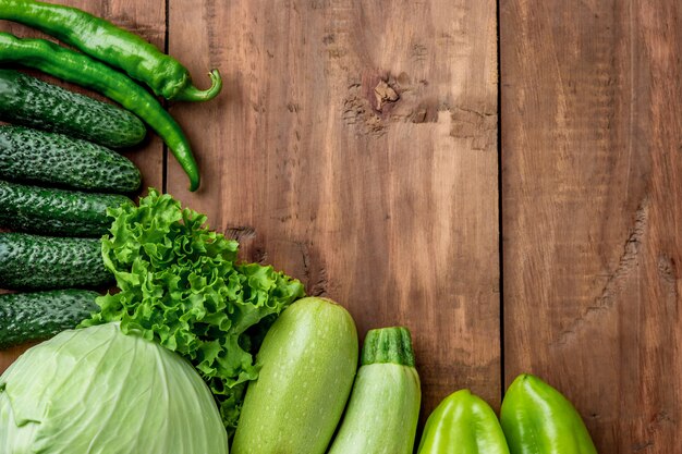 De groene groenten op houten tafel