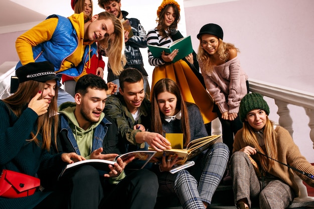 De groep van vrolijke studenten zitten in een collegezaal voor de les.