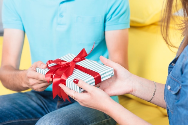 De hand die van de vrouw valentijnskaart gift van haar vriend ontvangt