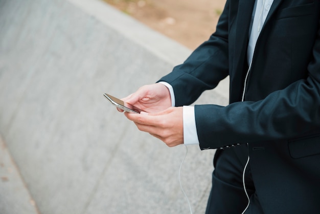 De hand die van de zakenman mobiele telefoon met behulp van