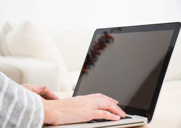 De hand van de vrouw het typen op laptop