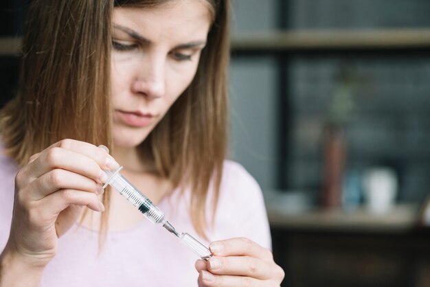 De hand vullende spuit van de vrouw met geneeskunde