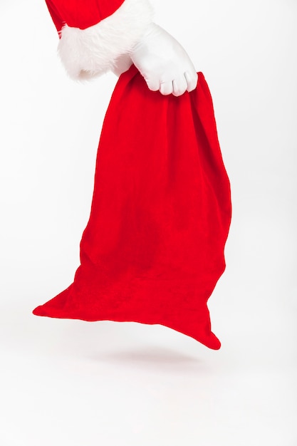 De handen die van de Kerstman rode zak van giften houden