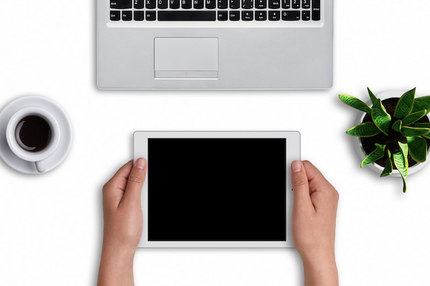 De handen die van de vrouw moderne tablet met het lege scherm over wit houden. Moderne apparaten: tablet en laptopcomputer