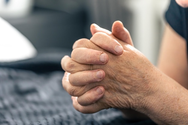 De handen van een oudere vrouw gevouwen in gebed