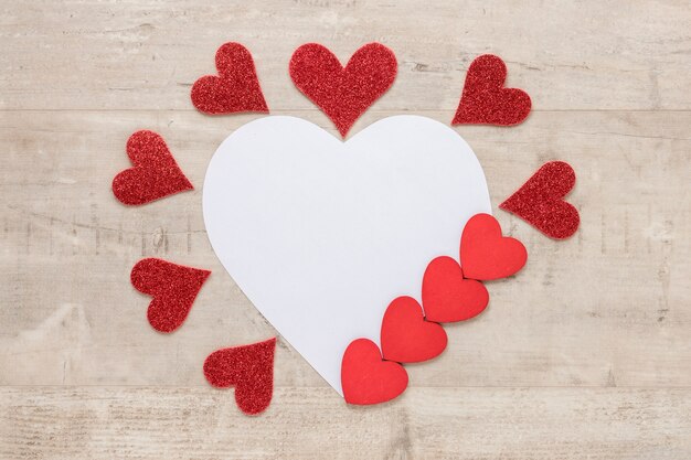 De harten van de valentijnskaartendag met document op houten achtergrond