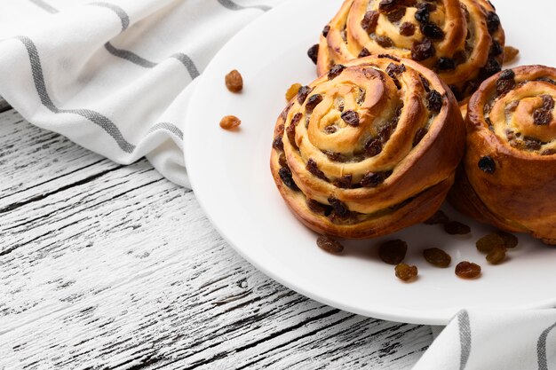 De heerlijke broodjes van kaneelrozijnen op houten lijst