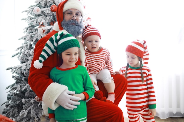 De helpers van de kerstman. schattige kinderen in kerst elf kostuums in een kamer prachtig versierd voor kerstmis. tijd van wonderen. cadeautjes van sinterklaas.
