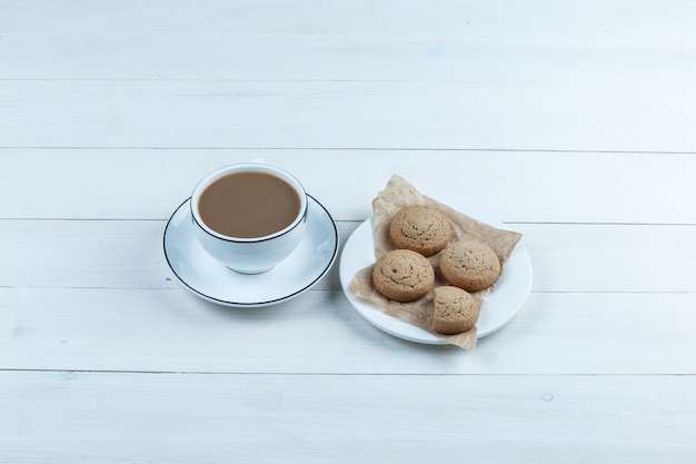 De hoge mening van de hoekkoekjes op witte plaat met kop koffie op witte houten raadsachtergrond. horizontaal