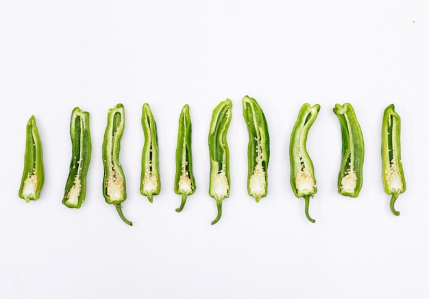 De hoogste peper van de menings groene Spaanse peper die op witte horizontaal wordt gesneden