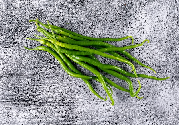 Gratis foto de hoogste peper van de menings groene spaanse peper op grijze horizontale steen