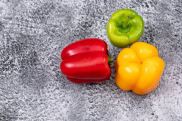 Gratis foto de hoogste peper van de meningsgroene paprika op grijze horizontale steen