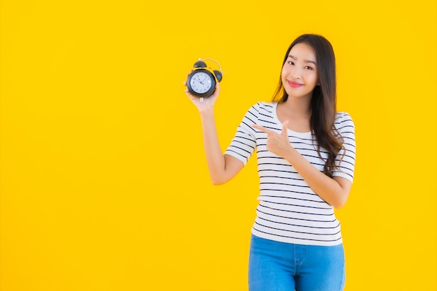 de jonge Aziatische vrouw toont klok of alarm