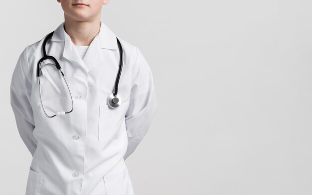 De jonge jongen kleedde zich omhoog als dokter met exemplaarruimte