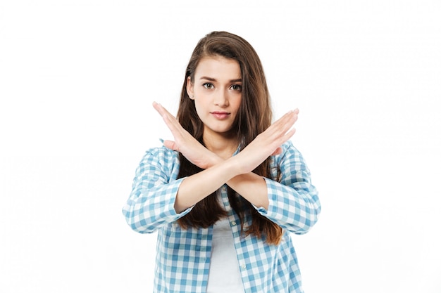 Gratis foto de jonge vrij jonge vrouw kruist haar wapens om gebaar nr te tonen