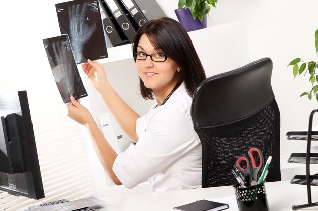 De jonge vrouw arts bekijkt röntgenstraal