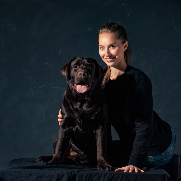 Gratis foto de jonge vrouw die een hond van het mengelingsras koestert