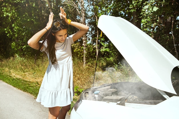 De jonge vrouw gaf de auto pech terwijl ze onderweg was om uit te rusten. Ze probeert de kapotte zelf te repareren of zou moeten liften. Nerveus worden