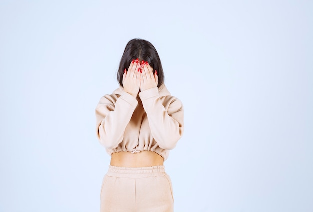 De jonge vrouw in een roze hoodie ziet er moe en slaperig uit