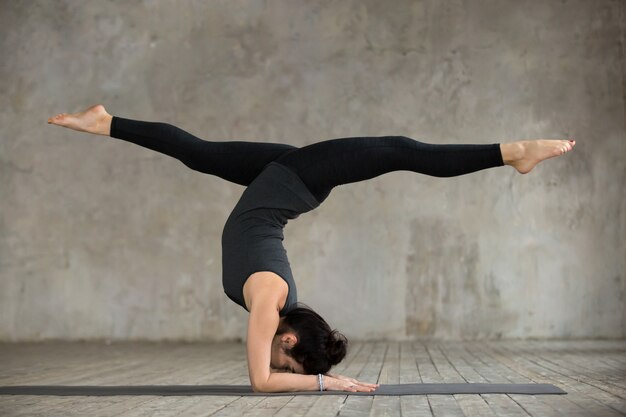 De jonge vrouw in handstand stelt