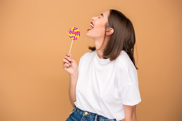 De jonge vrouw met kleurrijke lollipop