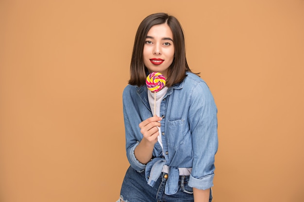 De jonge vrouw met kleurrijke lollipop