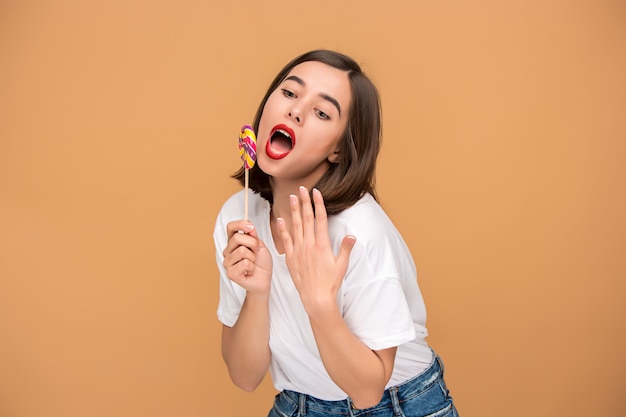 De jonge vrouw met kleurrijke lollipop