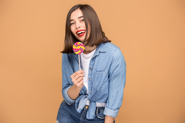 De jonge vrouw met kleurrijke lollipop