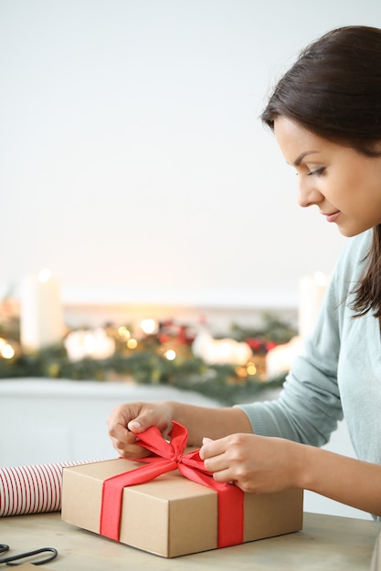 Gratis foto de jonge vrouw verpakkende kerstmis stelt voor