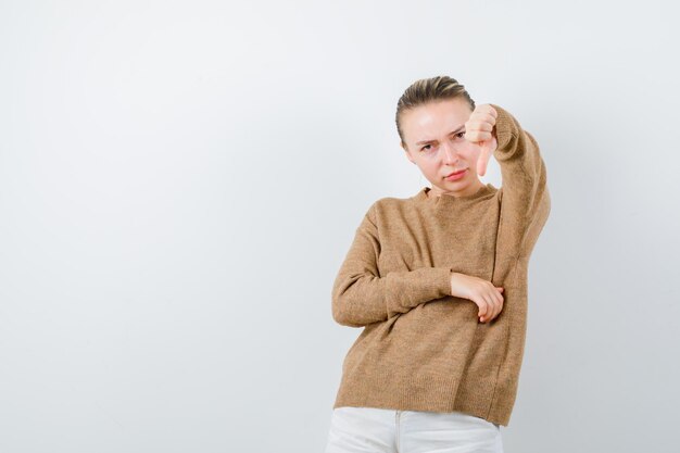 De jonge vrouw vertoont slechte emotie op witte achtergrond