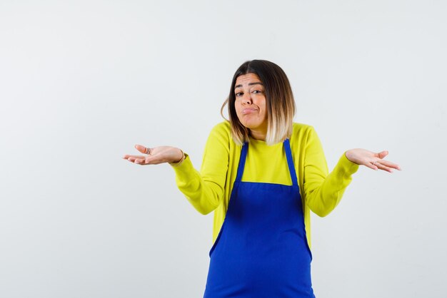 De jonge vrouw voelt zich verdrietig door haar handen wijd te openen op een witte achtergrond