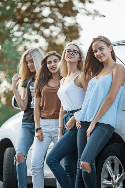 De jonge vrouwen die zich dichtbij de auto bevinden