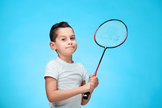 De jongen met badmintonrackets buitenshuis