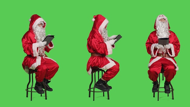 Gratis foto de kerstman werkt op een digitale tablet