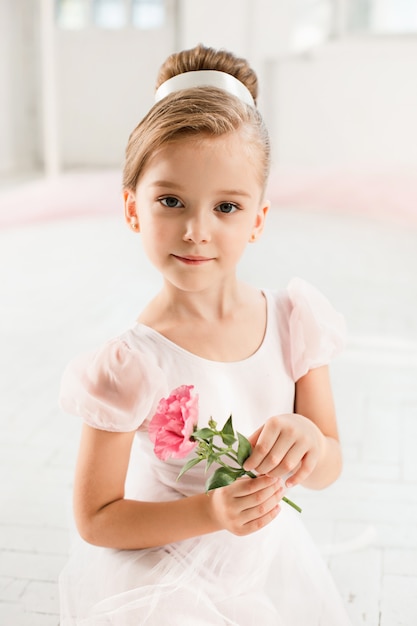 De kleine balerina in witte tutu in de klas bij het ballet