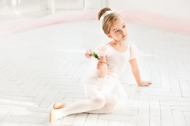 De kleine balerina in witte tutu in de klas bij het ballet